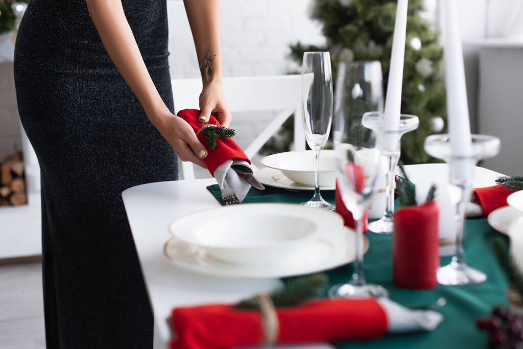 partial view of woman setting table with cutlery wrapped in festive napkins - Photo, Image