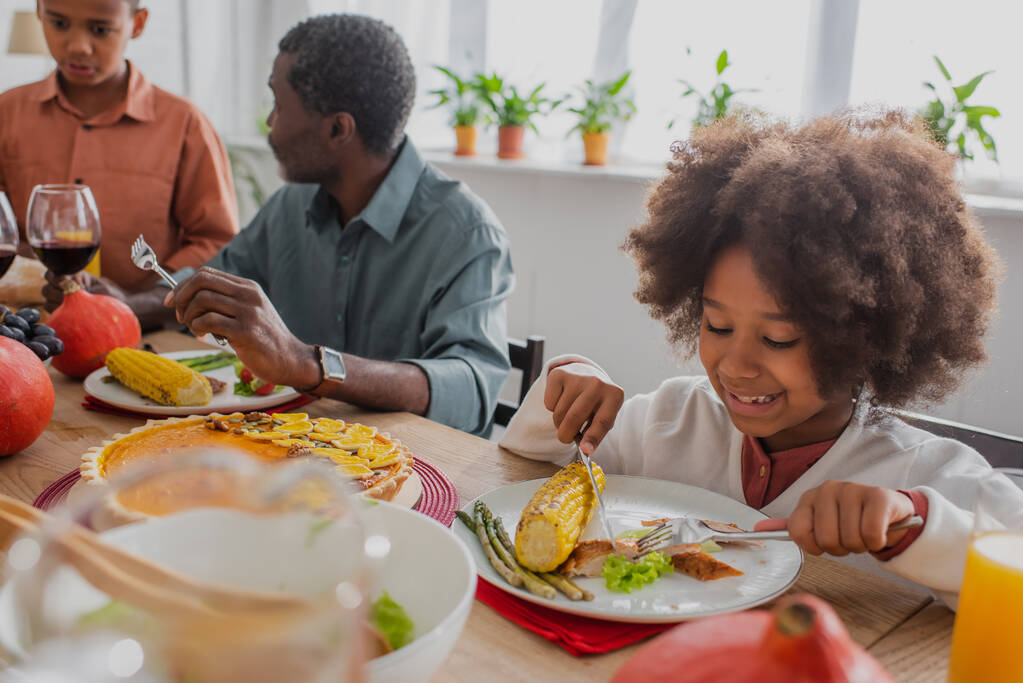 アフリカ系アメリカ人の少女に感謝祭の夕食がある - 写真・画像