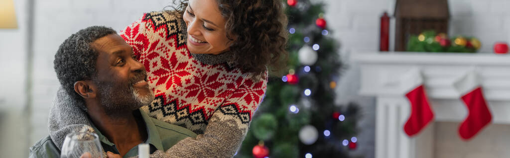 vidám afro-amerikai apa és lánya mosolyognak egymásra a karácsonyi ünnepség, banner - Fotó, kép
