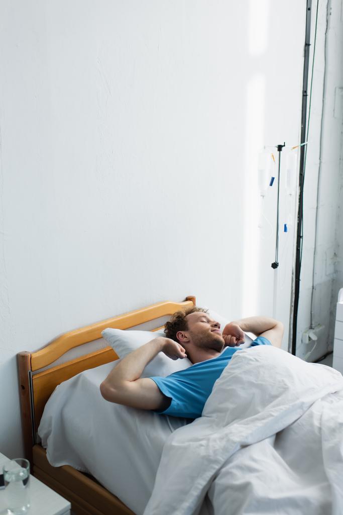 Blick auf den wachen Patienten, der sich auf dem Krankenhausbett dehnt - Foto, Bild