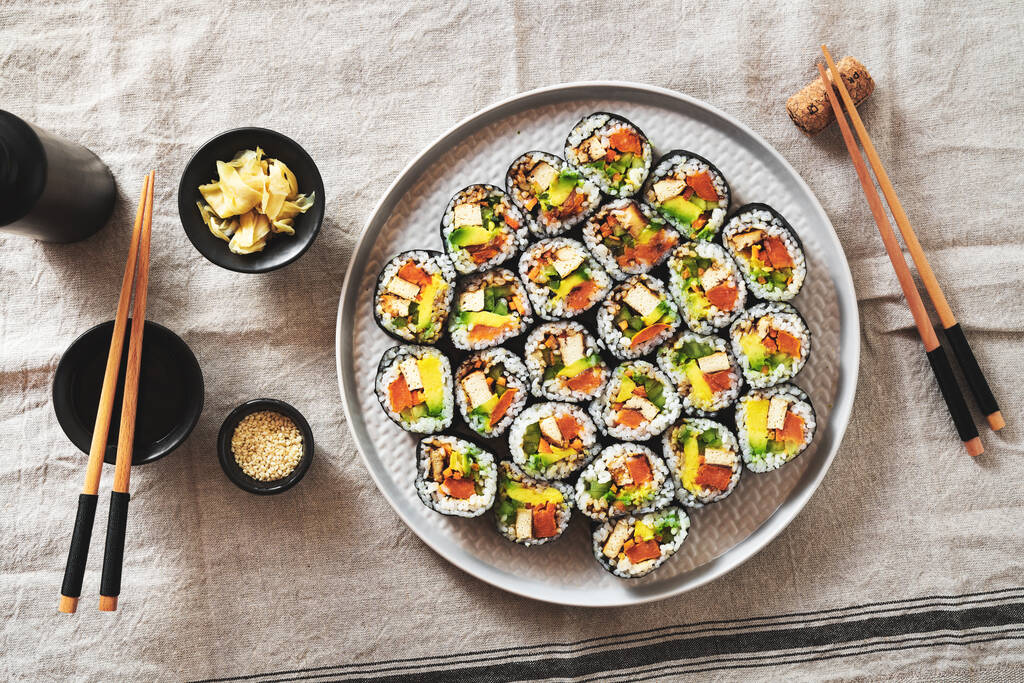 vegán sushi tofuval és avokádóval egy tányéron, vászonszalvétán.. - Fotó, kép