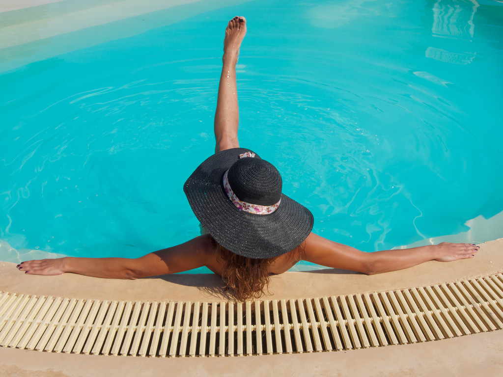 Uma menina está relaxando em uma piscina
 - Foto, Imagem