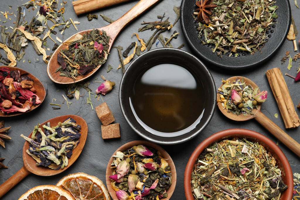Composition plate avec thé frais infusé et feuilles sèches sur table grise - Photo, image