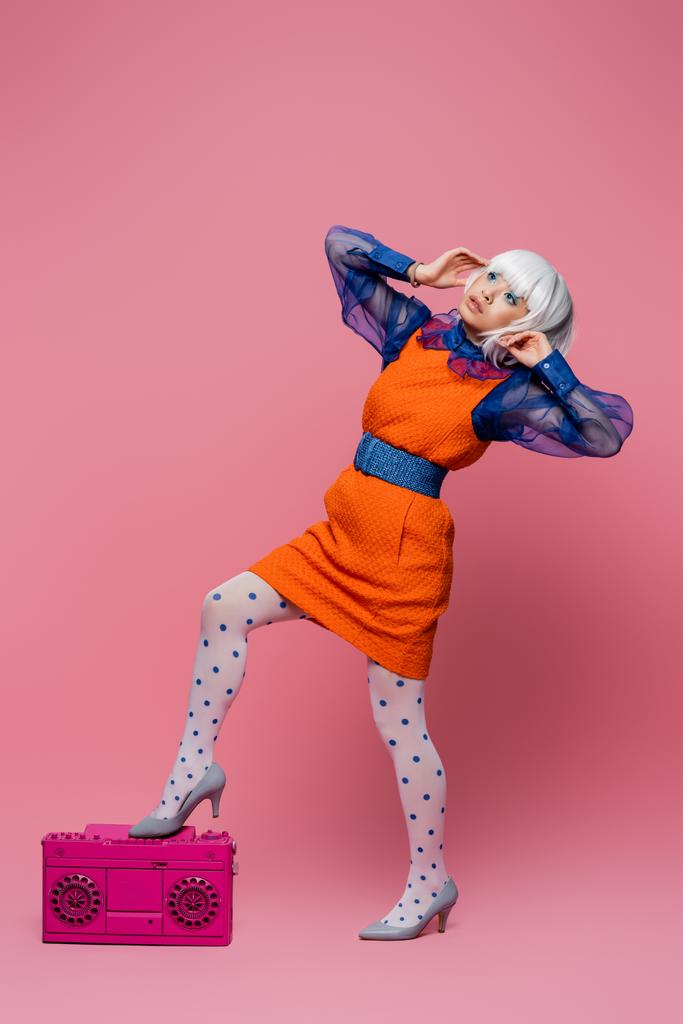 Asiático modelo de arte pop em peruca branca posando perto boombox no fundo rosa - Foto, Imagem