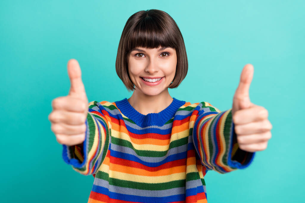 Фотопортрет усміхненої боб волохатої жінки в смугастій пуловері, що показує знак великого пальця вгору ізольований яскравий кольоровий фон
 - Фото, зображення