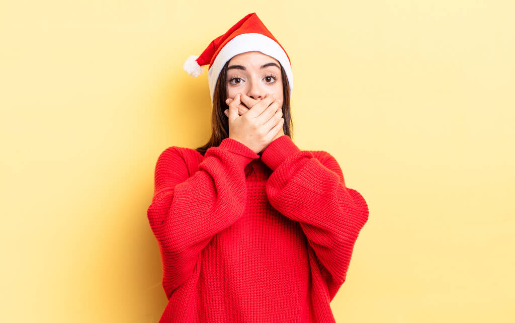 giovane donna ispanica che copre la bocca con le mani con uno shock. Natale e nuovo concetto di anno - Foto, immagini