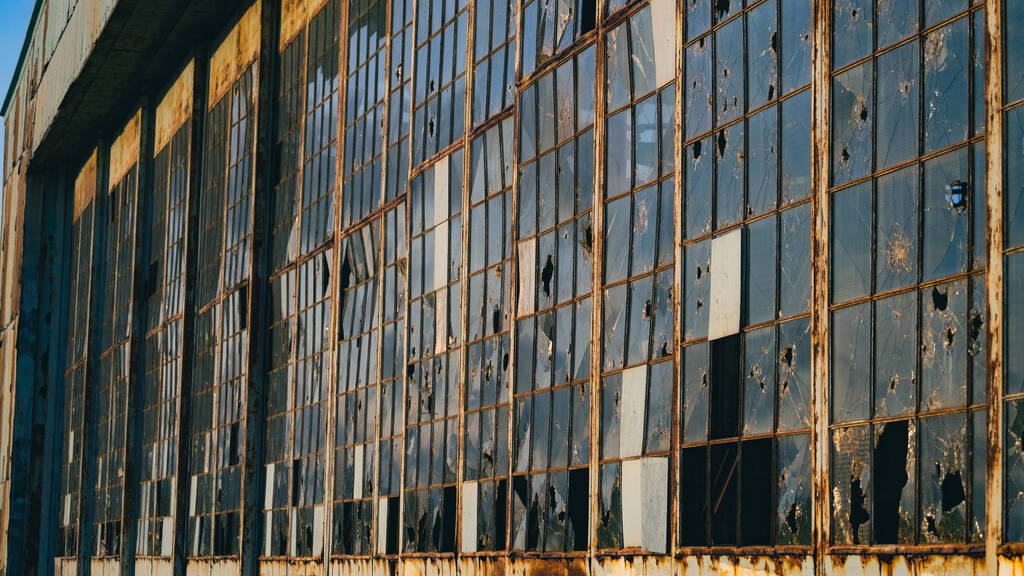 Egy elhagyatott épület törött üvegablakokkal. - Fotó, kép