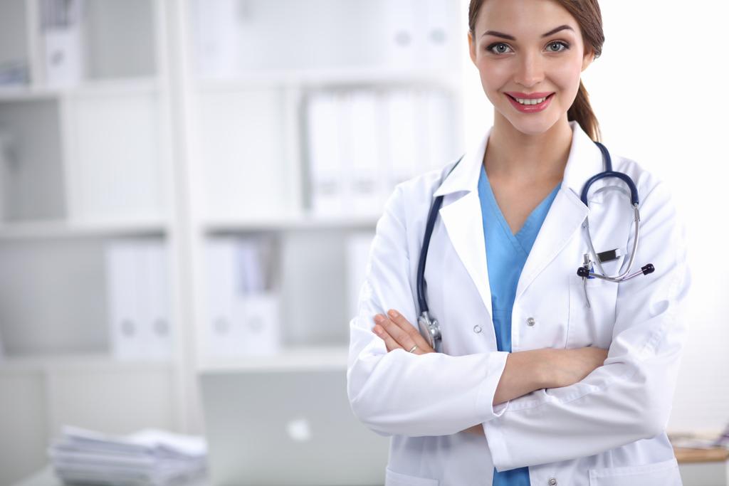 Портрет молодой женщины-врача в белом халате, стоящей в больнице - Фото, изображение