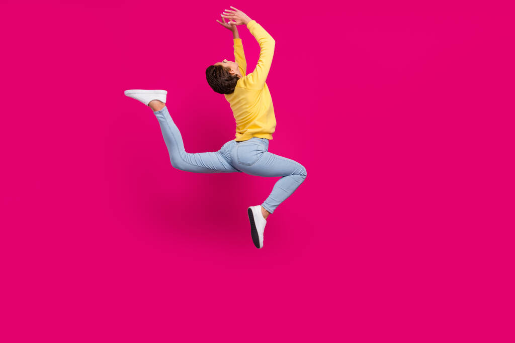 Foto de doce funky jovem vestido pulôver amarelo saltando alongamento isolado cor-de-rosa fundo - Foto, Imagem