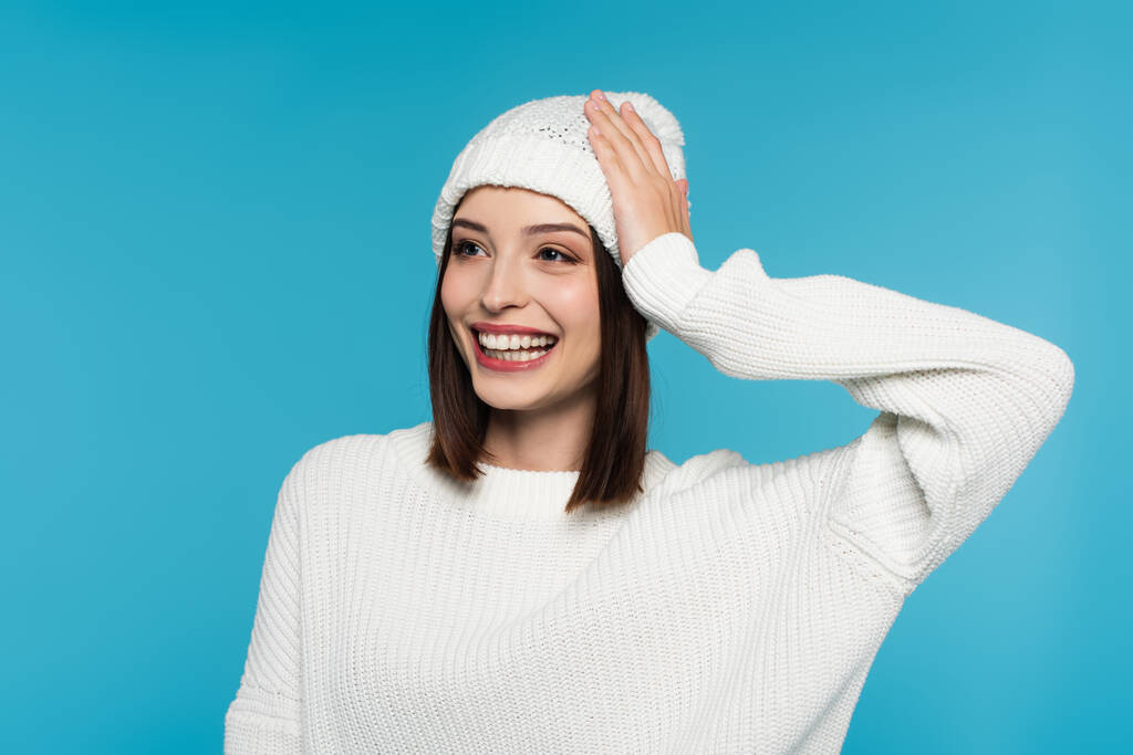 正の女性で白い帽子とセーター隔離上の青  - 写真・画像