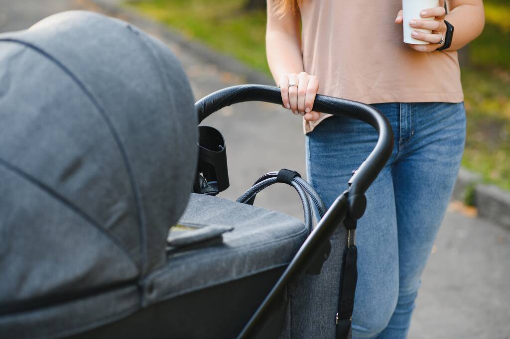 Mother with baby carriage in the park - Photo, Image