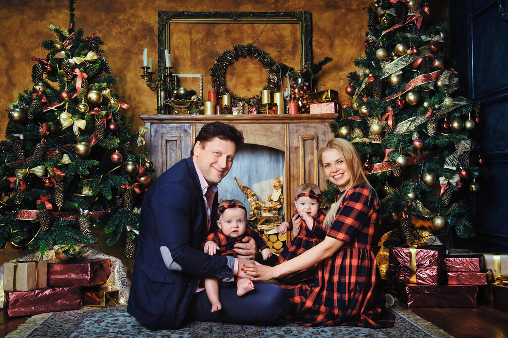 Una gran familia feliz con sus hijos en el interior de Año Nuevo de la casa junto a la chimenea junto al árbol de Navidad. - Foto, imagen