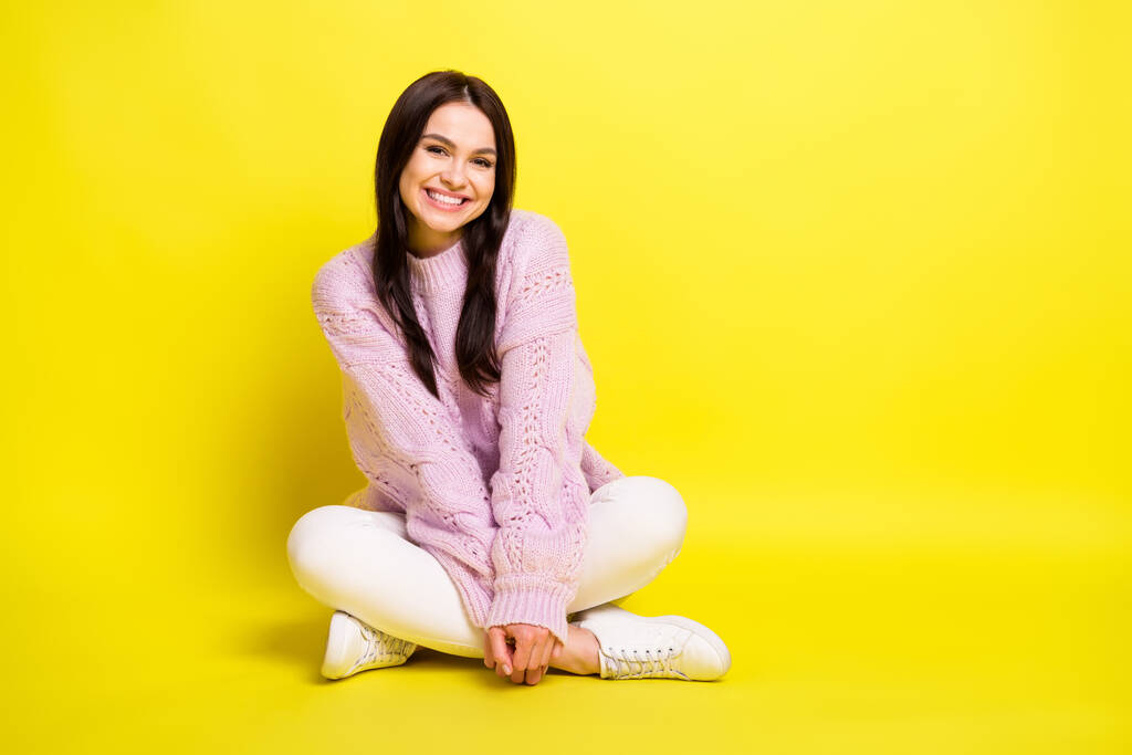 Foto de larga duración de la señora joven en reposo sentarse usar pantalones de suéter aislados en el fondo de color amarillo - Foto, Imagen