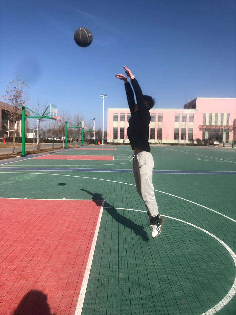 Молодий чоловік грає в баскетбол на дворі
 - Фото, зображення