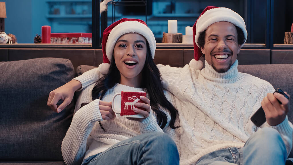 excited african american couple watching movie on christmas  - Photo, Image