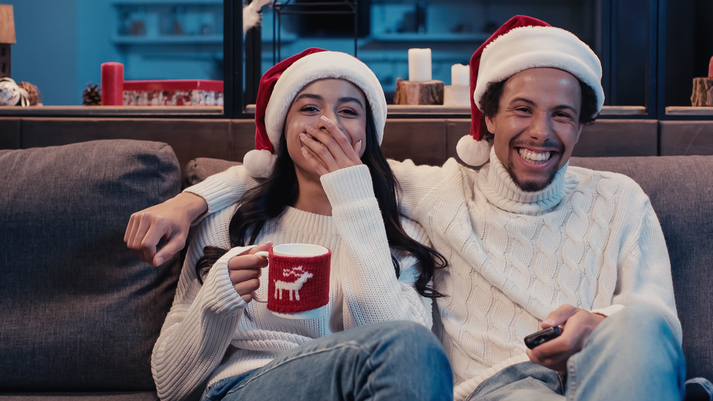 ευτυχισμένο ζευγάρι Αφροαμερικανών που βλέπουν κωμική ταινία τα Χριστούγεννα.  - Φωτογραφία, εικόνα