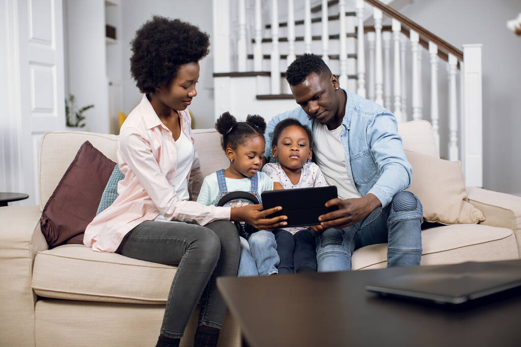 Familia africana sentada en el sofá y usando la tableta - Foto, Imagen