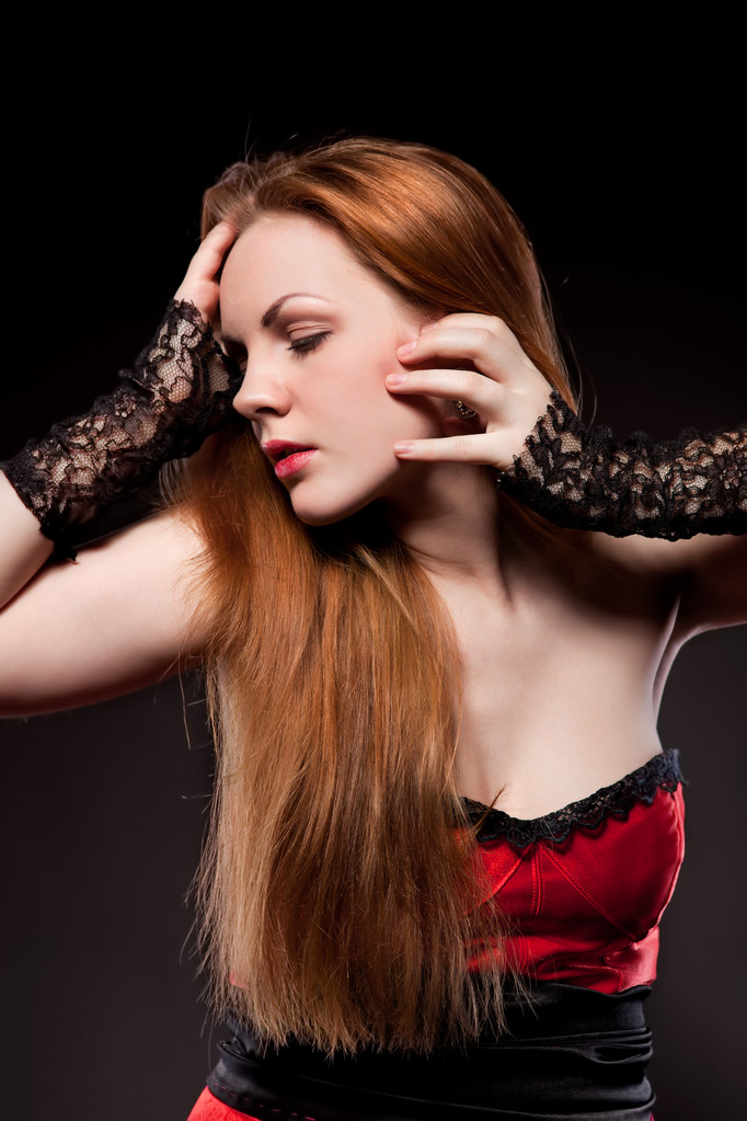 ελκυστική σέξι γυναίκα με κόκκινο μακριά μαλλιά σε μαύρο - Φωτογραφία, εικόνα