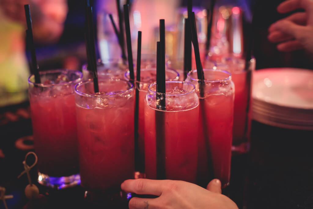 Pohled na nastavení alkoholu na stravovacím stolku, řada červených alkoholických koktejlů na party, martini, spritz a další na zdobeném cateringovém stolku - Fotografie, Obrázek