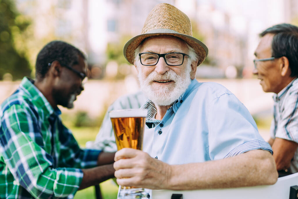 grupo de amigos mayores bebiendo una cerveza en el parque. Conceptos de estilo de vida sobre la antigüedad y la tercera edad - Foto, imagen