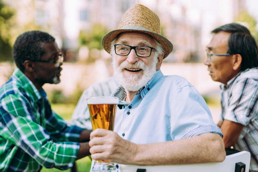 Gruppe älterer Freunde, die im Park ein Bier trinken. Lebensstilkonzepte über das Alter und das dritte Lebensalter - Foto, Bild
