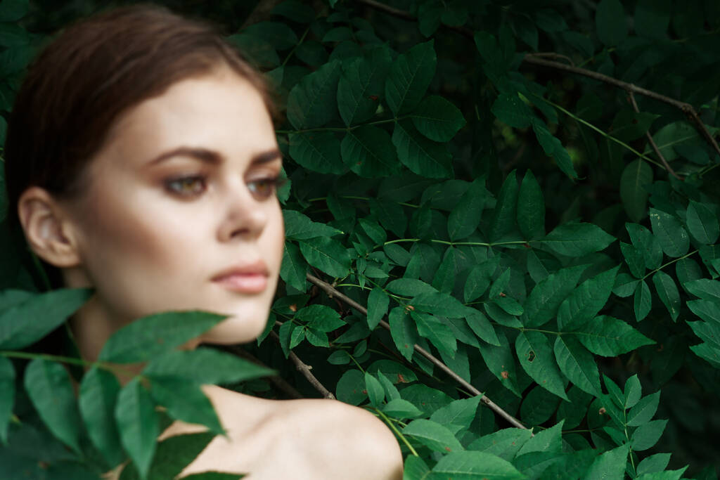 ελκυστική γυναίκα φροντίδα του δέρματος γυμνά ώμους πράσινο αφήνει τη φύση close-up - Φωτογραφία, εικόνα