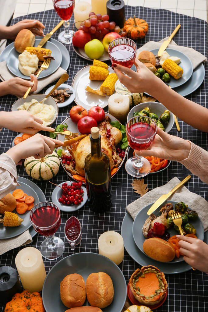 Mensen vieren Thanksgiving dag, juichen en hebben heerlijk diner aan feestelijke serveertafel - Foto, afbeelding
