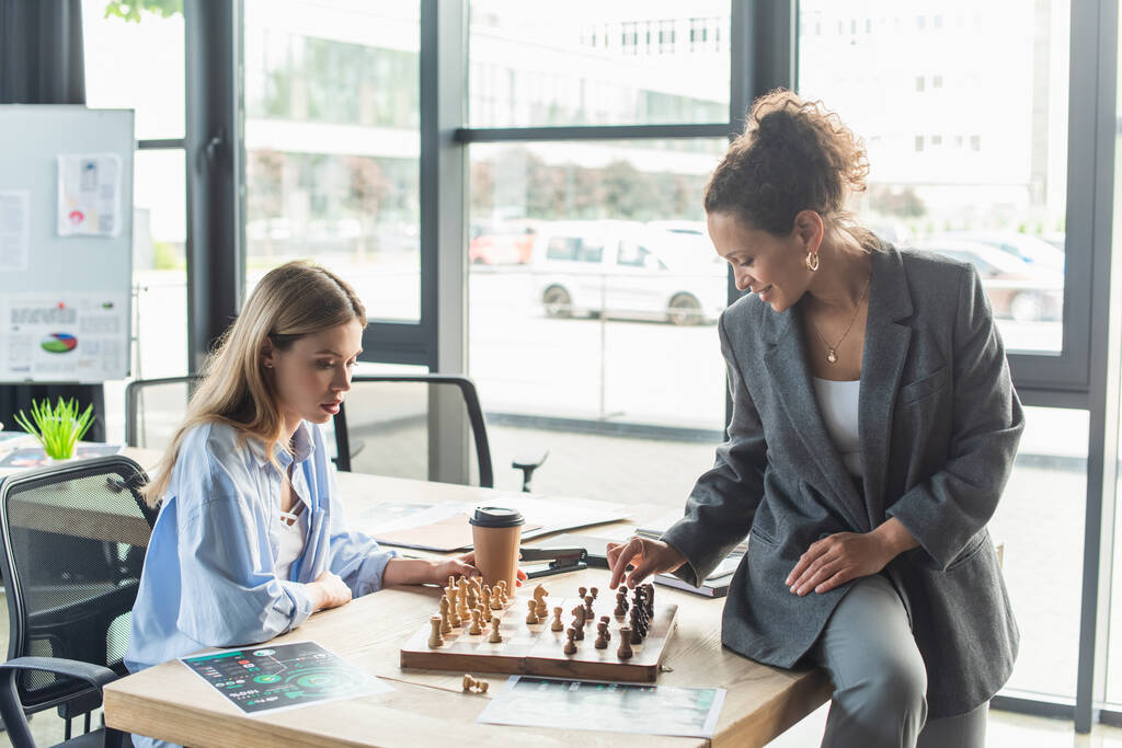 African american businesswoman playing chess with young colleague in office  - Photo, Image