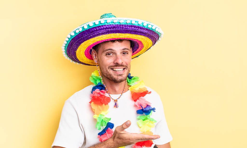 joven hombre guapo sonriendo alegremente, sintiéndose feliz y mostrando un concepto. concepto de partido mexicano - Foto, imagen