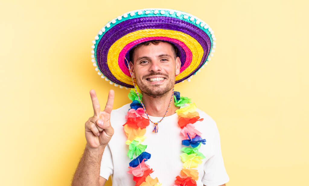 young handsome man smiling and looking friendly, showing number two. mexican party concept - Photo, Image