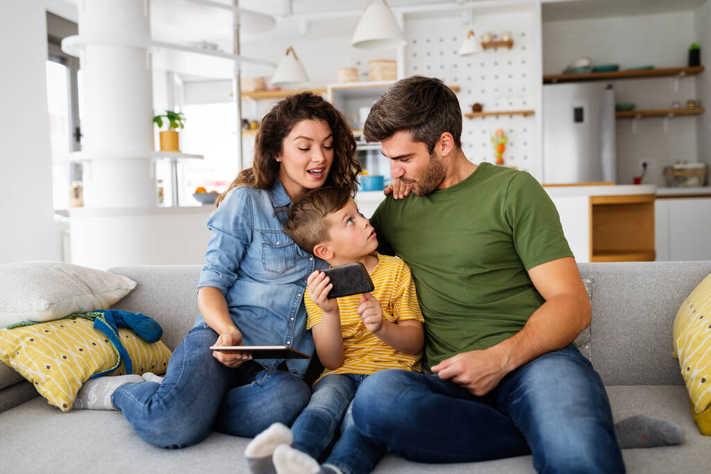 Junge glückliche Familie, die Spaß hat, spielerisch zu Hause ist. Technologiemenschen-Konzept. - Foto, Bild