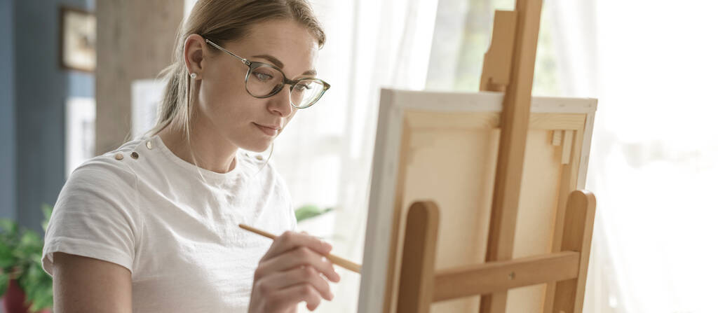 Fiatal magabiztos nő festmény vászonra az ő stúdió, kreativitás és hobbi koncepció - Fotó, kép