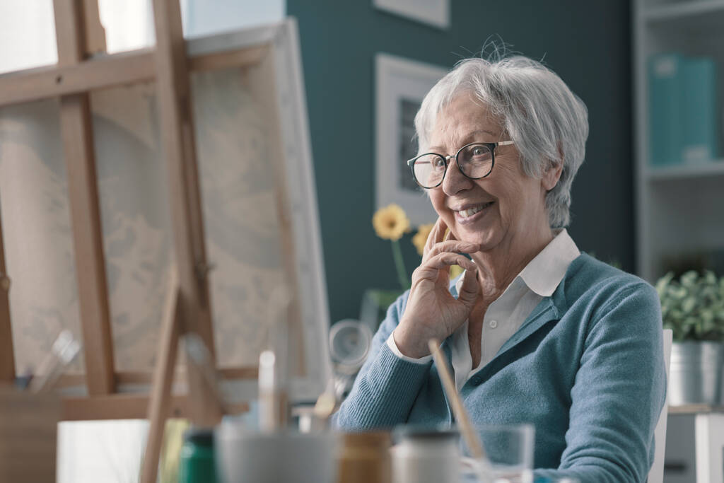 Mujer mayor feliz mirando su obra de arte terminado, hobby y concepto de creatividad - Foto, Imagen