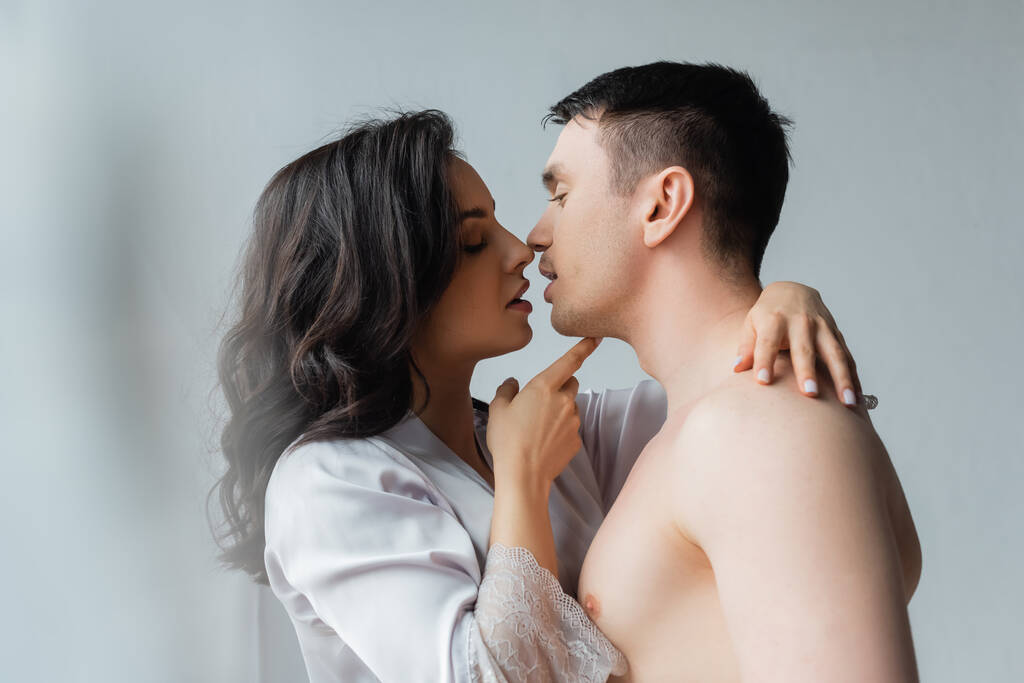 oldal kilátás fiatal nő csók férfi a hálószobában  - Fotó, kép
