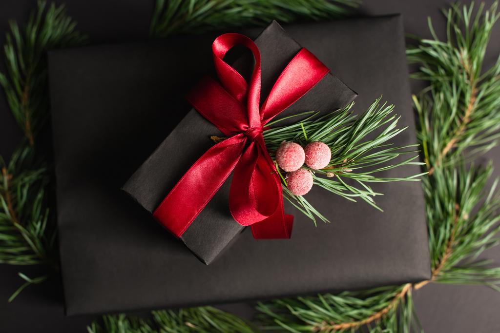 верхний вид подарочной коробки с красной лентой и украшения на черном  - Фото, изображение