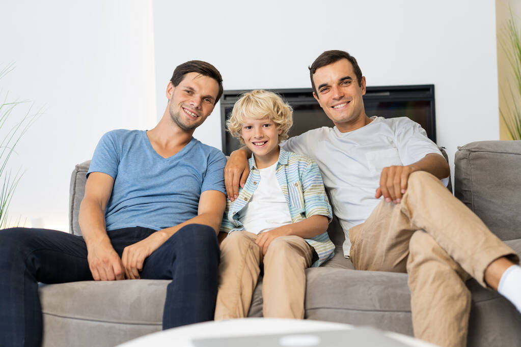 Lgbt család, meleg pár örökbefogadott fiúval - Homoszexuális szülők gyermekükkel, akik otthon szórakoznak - Fotó, kép