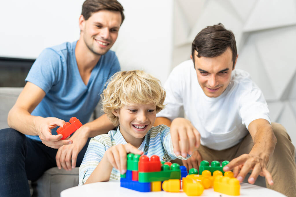 Famiglia Lgbt, coppia gay con figlio adottivo genitori omosessuali con il loro bambino divertirsi a casa - Foto, immagini