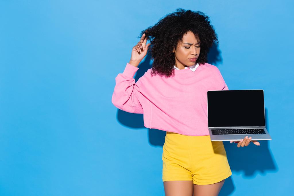 figyelmes afro-amerikai nő néz laptop üres képernyő kék - Fotó, kép