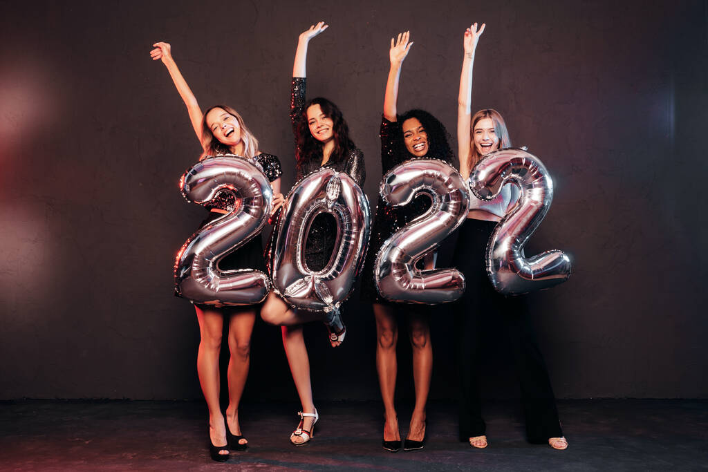 Belles femmes célébrant le Nouvel An. Joyeux magnifique femme dans des robes de soirée sexy élégantes tenant des ballons en argent 2022, s'amusant à la fête du Nouvel An. Célébration des Fêtes.  - Photo, image
