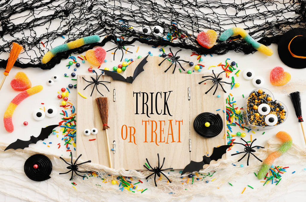 εορταστική εικόνα του Halloween. νυχτερίδες, αράχνες και ξύλινο σκελετό με κείμενο πάνω από λευκό ξύλινο τραπέζι - Φωτογραφία, εικόνα