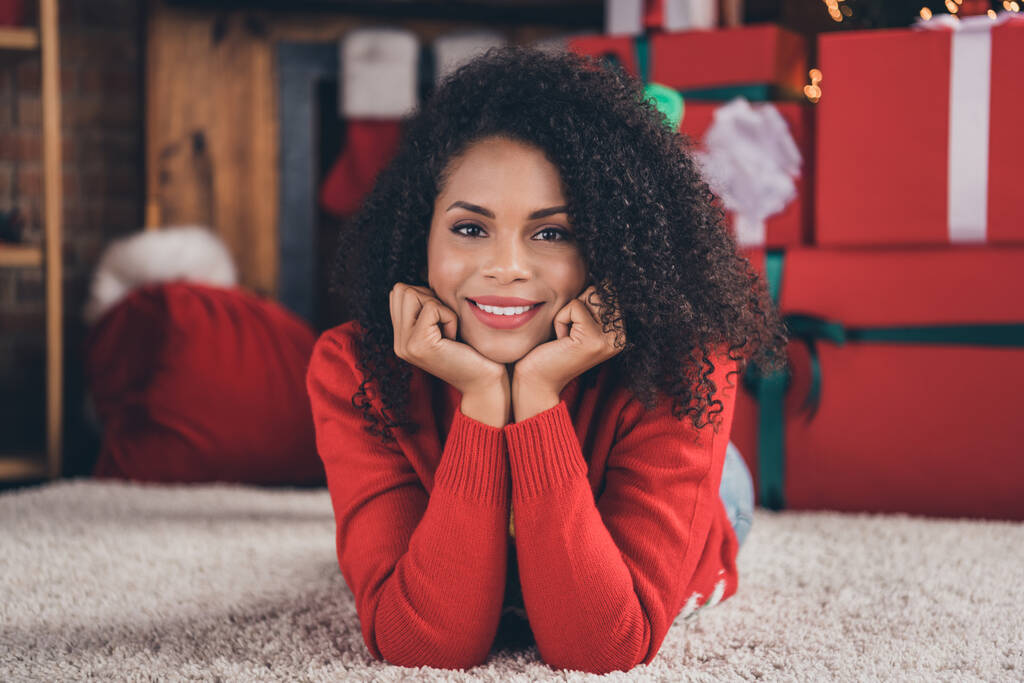 Φωτογραφία της νεαρής afro γυναίκα ευτυχισμένη θετικά χέρια χαμόγελο αγγίζουν τα μάγουλα όνειρο ξαπλωμένη πάτωμα διακοπές υπόλοιπο του νέου έτους σε εσωτερικούς χώρους - Φωτογραφία, εικόνα
