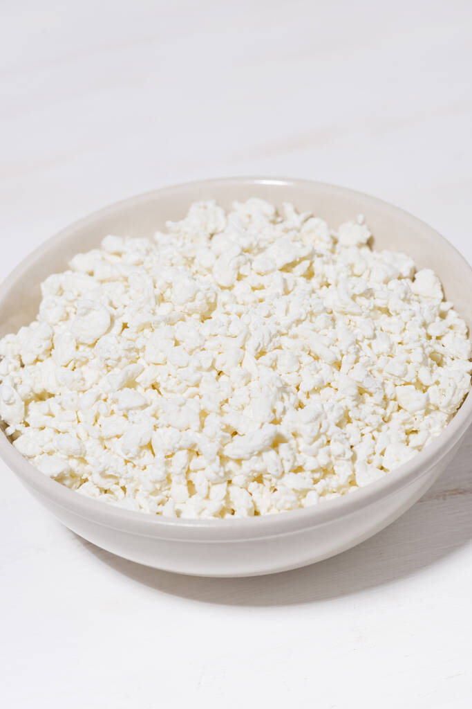 tigela de queijo cottage fazenda fresca em um fundo branco, close-up
 - Foto, Imagem