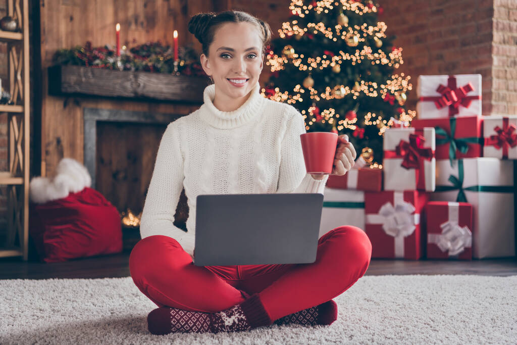 Teljes test fotó fiatal lány boldog pozitív mosoly ül padló használata laptop kávé tea internet ünnep este zárt térben - Fotó, kép