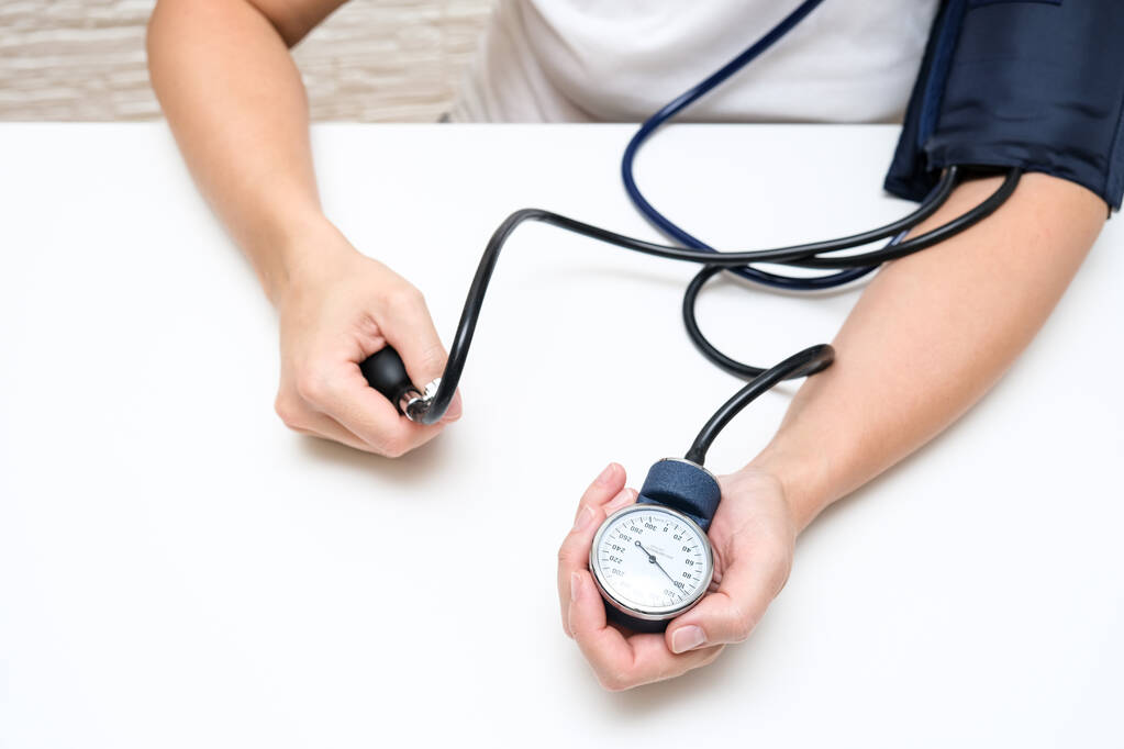 Mulher medindo a pressão arterial sozinha em casa, controle de pressão para prevenir problemas cardiolvasculares cardíacos de pessoas com alto risco. - Foto, Imagem