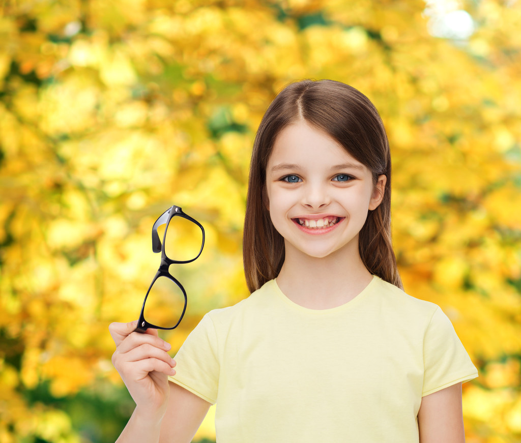 siyah gözlük tutan gülümseyen sevimli küçük kız - Fotoğraf, Görsel