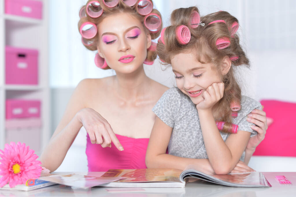  madre e figlioletta con bigodini per capelli rivista di lettura - Foto, immagini