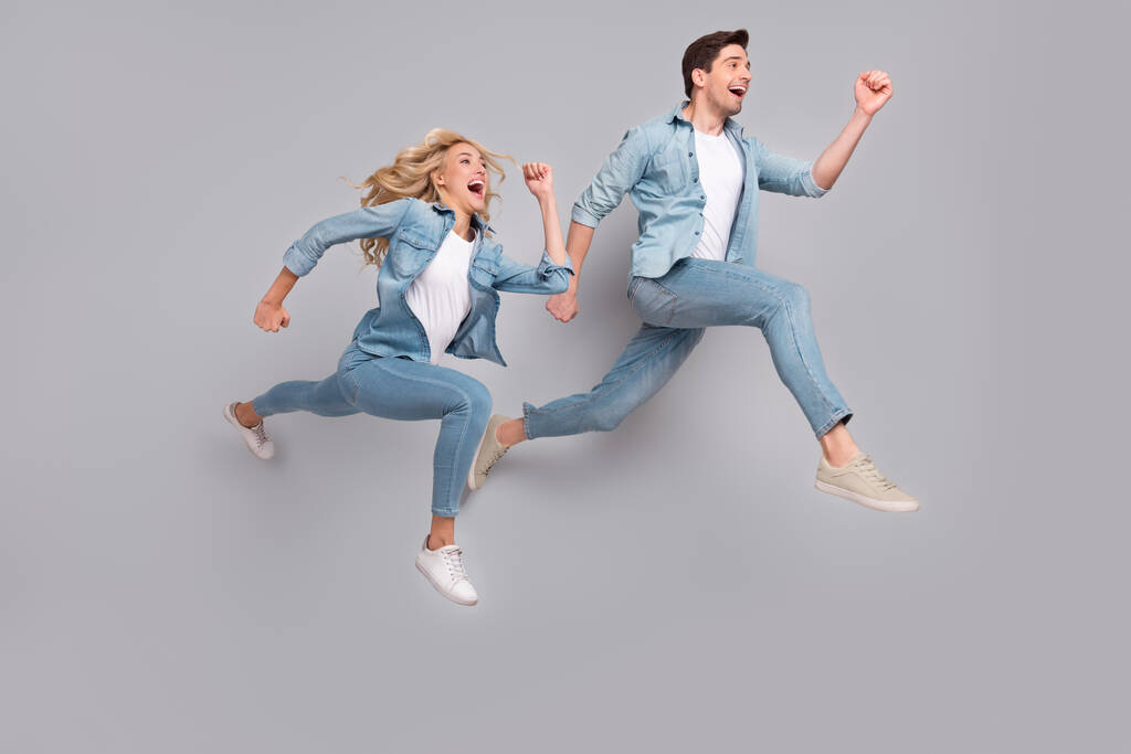 Profiel foto van grappig energiek paar jump run rush slijtage casual jeans outfit geïsoleerde grijze kleur achtergrond - Foto, afbeelding