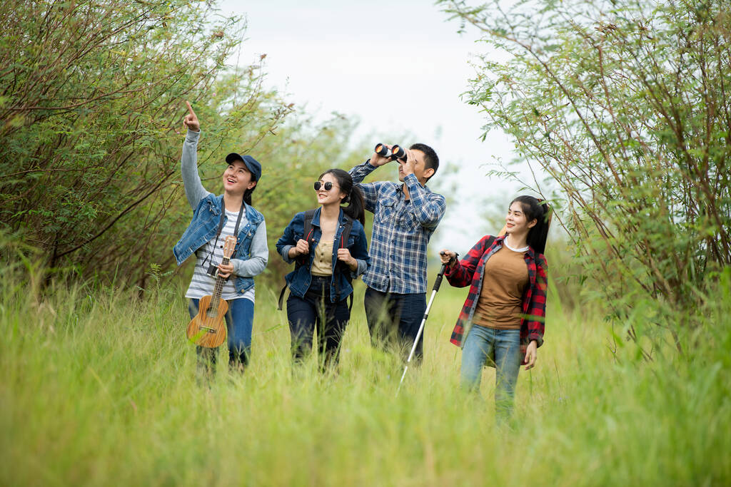 Группа азиатских друзей путешественник с рюкзаком приключения проведение карты, чтобы найти направления и прогулки расслабиться в джунглях леса на открытом воздухе для отдыха изучить образование природы на отдыхе. Концепция путешествий и образа жизни - Фото, изображение