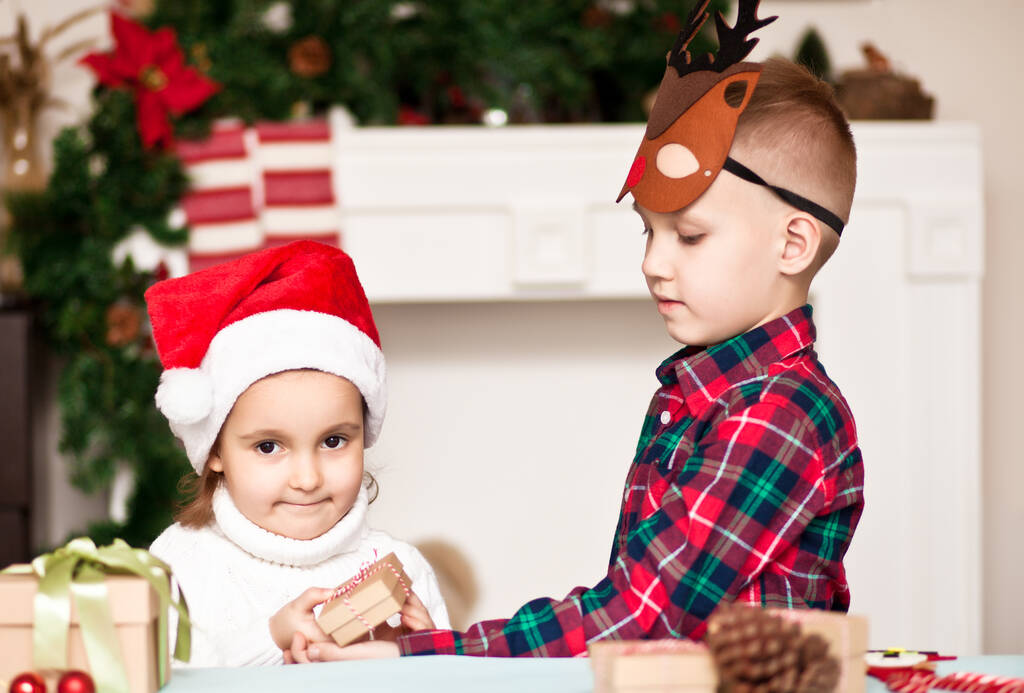 Chłopiec i dziewczyna brat i siostra dają sobie prezenty świąteczne - Zdjęcie, obraz