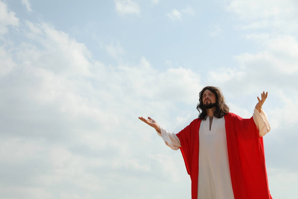 Jesucristo levantando las manos contra el cielo azul. Espacio para texto - Foto, imagen